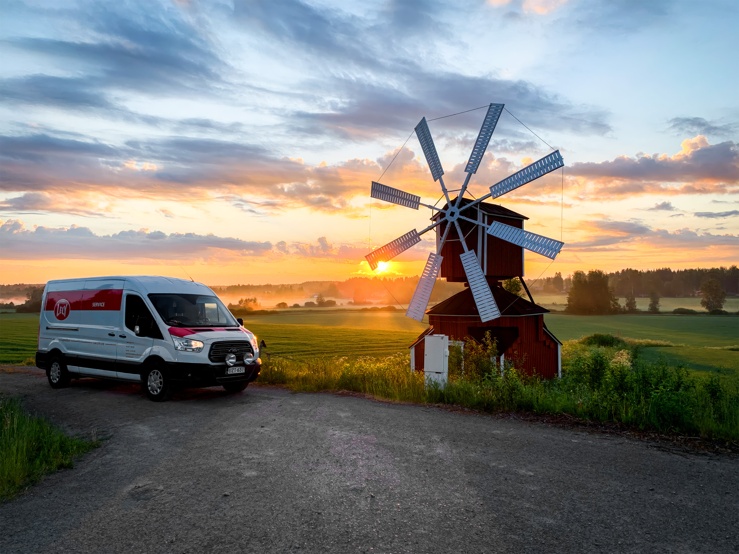 Robottihuollon pakettiauto kuvattuna auringonnousun aikaan